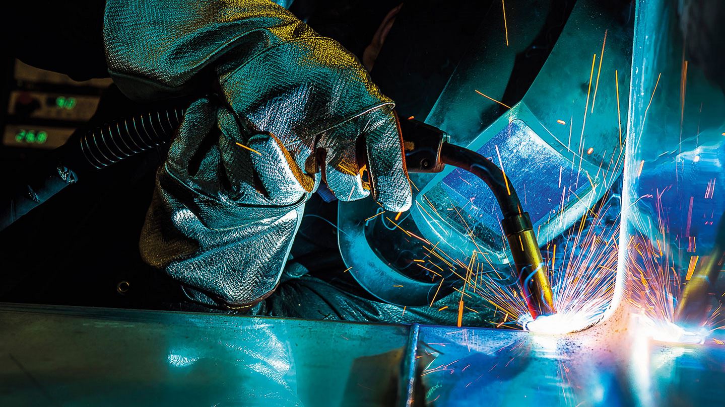 Lasser aan het werk met beschermende uitrusting en blauwe achtergrondverlichting